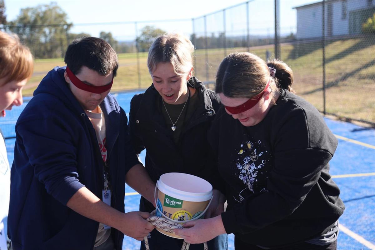 Blindfolded participants working a challenge as a group