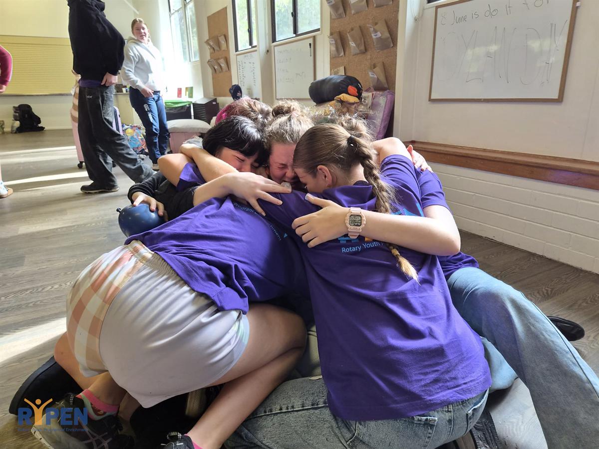 A group of participants in a huddle together at camp