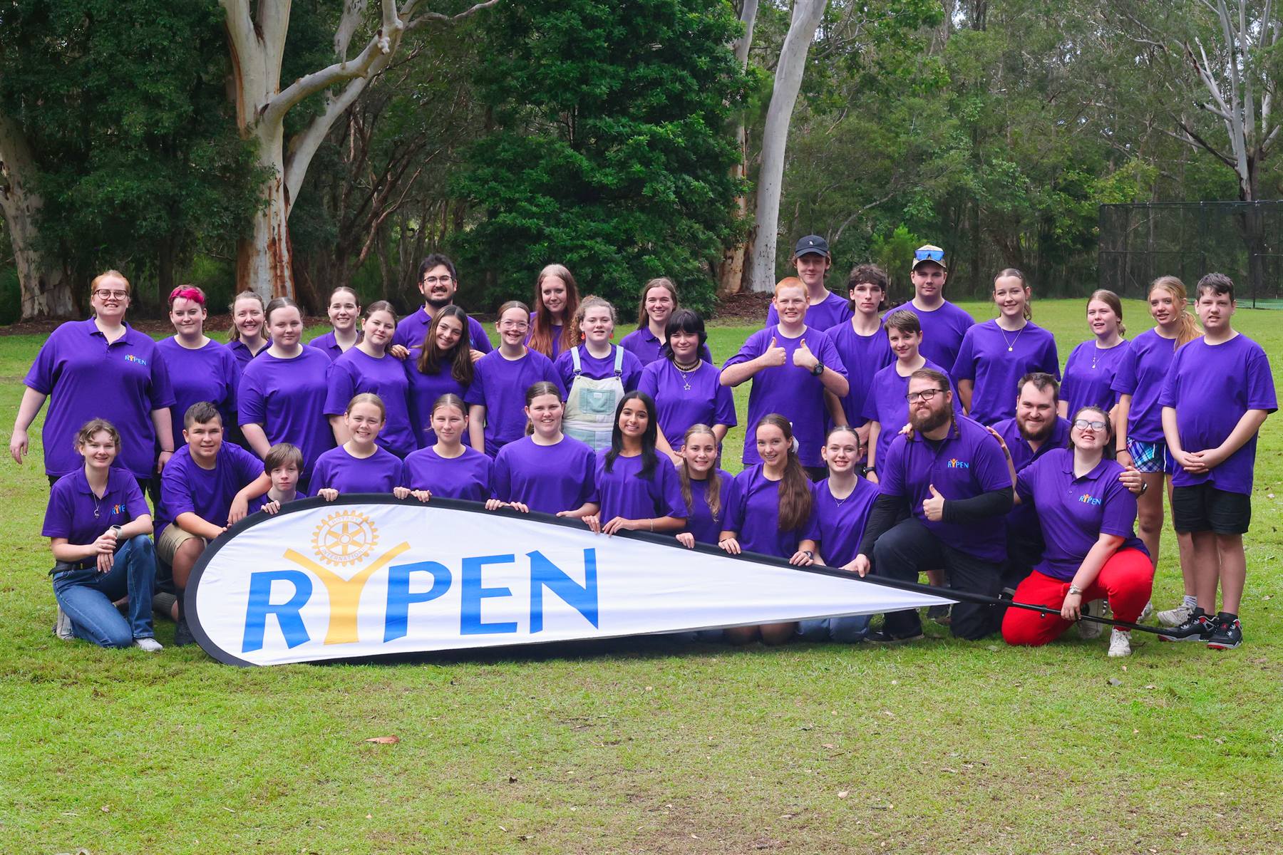 RYPEN participants and leaders gathered around the RYPEN flag at camp