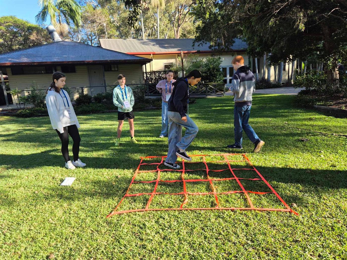 A team working through a grid challenge on the grass