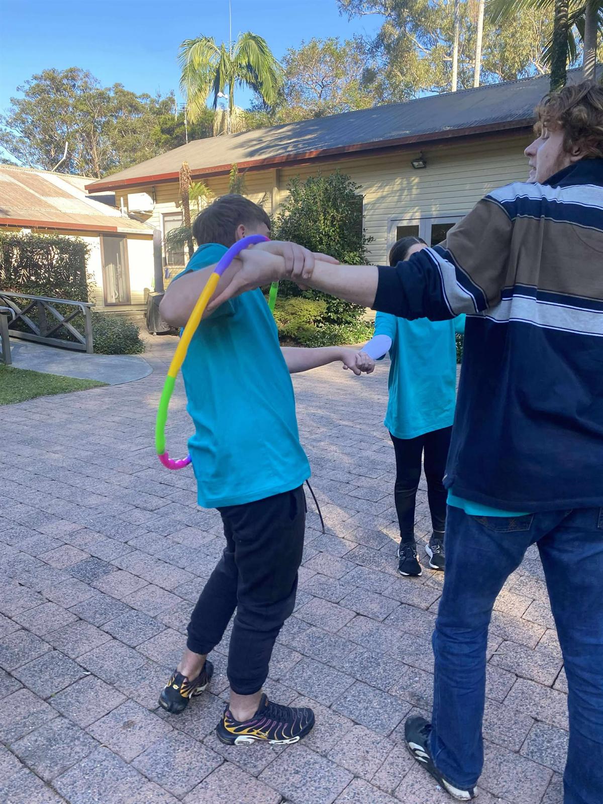 Participants passing a hoop around a linked circle
