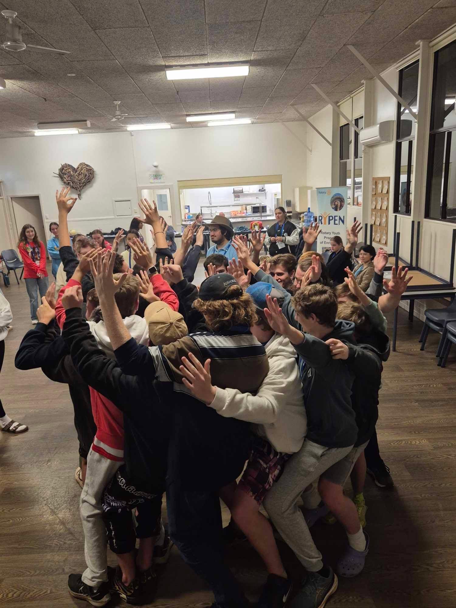 The whole camp packed into a huddle with arms raised